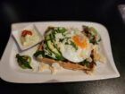 Herzhaftes Waffel-Frühstück: Frische Waffel belegt mit Avocado, Spiegelei, Rucola, Parmesan und serviert mit einer cremigen Kräutersoße – ein Highlight bei Mokka & Minze.