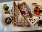 Knusprige Waffeln mit frischen Früchten und Schokoladensauce – perfekt für ein süßes Frühstück bei Mokka & Minze.